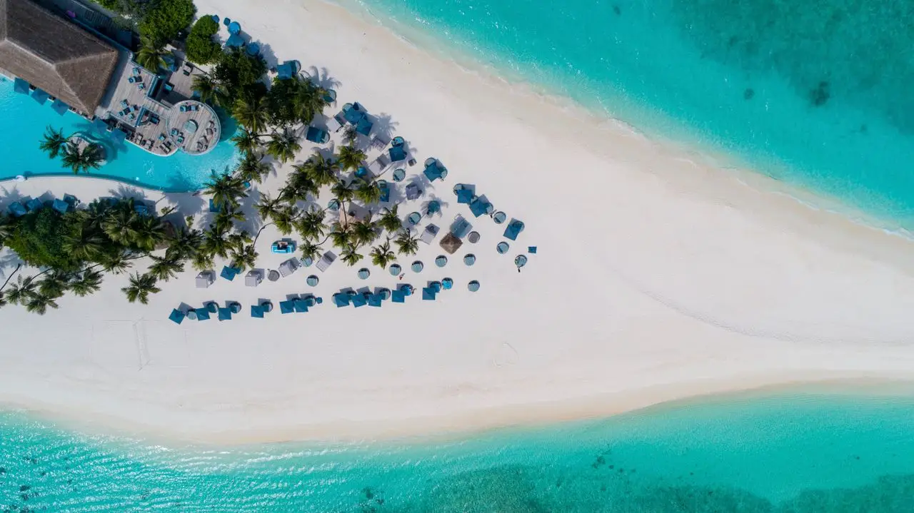Home Breathtaking aerial scenery of tropical resort located on small island with amazing sandy coastline equipped with beach umbrellas